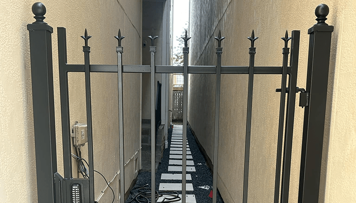 Black wrought iron walk-through gate with vertical pickets — Jorge Torres Fence installation, Houston TX